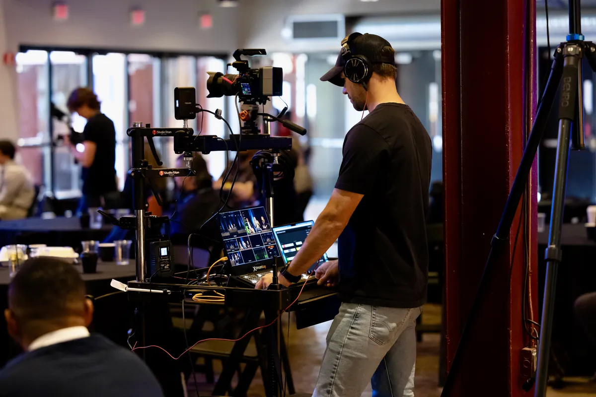 Readylight Media crew member operating a mobile live-production cart with camera and switcher during an event livestream